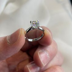 a person holding a diamond ring in their hand