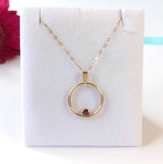 Feel fabulous in this solid 9ct yellow gold and ruby circular pendant.  Named the 'Oriana Rose', meaning Golden Sunrise, this pendant shimmers and shines around your neck, evoking a real festive feel. Symbolising the circle of life in a year, the Oriana Rose is an ideal Valentine's Day gift. The ruby is a rich and vibrant red; red being the colour of  love and glints beautifully in its rub over setting. You don't need to worry about buying the correct size; this pendant fits all and has a clip on bail so you can wear it with or without the bail and includes the chain photographed. So why do you need this pendant?  A ring might not be the exact message you want to convey and bracelets are tricky to size as well. This pendant is on trend, but is unique in its design. My silver and gold penda Yellow Gold Birthstone Jewelry Round Shape, Yellow Gold Round Birthstone Jewelry, Full Circle Yellow Gold Jewelry As Gift, Yellow Gold Circle Pendant Necklace Gift, Yellow Gold Round Pendant Necklace For Anniversary, Yellow Gold Round Jewelry For Valentine's Day, Ruby Round Pendant Necklace In Yellow Gold, Yellow Gold Ruby Round Pendant Jewelry, Yellow Gold Ruby Round Pendant Necklace