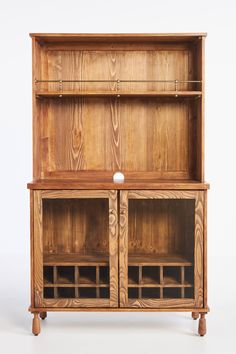 a wooden bookcase with two glass doors and shelves on one side, in the middle