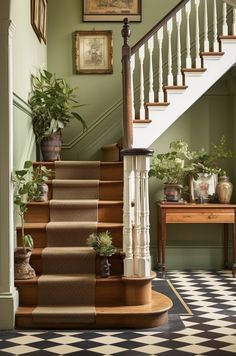 a staircase with potted plants and pictures on the wall