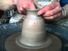 a person making a vase on a potter's wheel