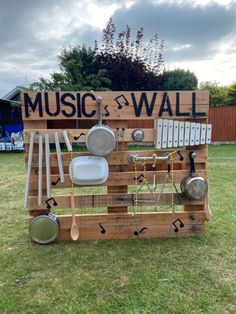 a sign made out of wooden pallets that says music and wall with pots and pans on it