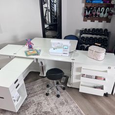 a sewing machine sitting on top of a white desk next to a dresser and chair