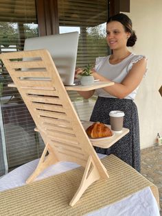 a woman holding a plate with food and a laptop on it