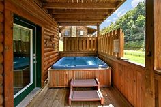 a hot tub on the back deck of a log cabin