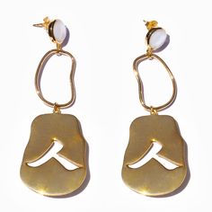 Human 18K gold plated brass earrings with mother of pearl. Size: One Size Length: 3 1/4" / 8.5cm Width: 1 1/8" / 3cm Laser logo engraving Nickel free gold plating Post and stopper base metal is 100% recycled 925 sterling silver Earring base metal is 100% recycled brass High polish Handcrafted Every mother of pearl is unique in color MYW06GP126MP Modern Gold Pearl Earrings, Yellow Gold Brass Pearl Earrings, Modern Gold Pearl Earrings In Sterling Silver, Modern Gold Pearl Drop Earrings, Gold Dangle Earrings With Mother Of Pearl, Silver Brass Pearl Earrings, Modern Single Pearl Earring In Metal, Modern Gold Metal Pearl Earrings, Single Gold Earring With Mother Of Pearl