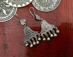 Egyptian Siwa Silver Earrings These stunning Egyptian Silver earrings are handmade by Artisan Silversmiths in the Siwa Oasis of Egypt which is renowned for incredible jewellery. These  lovely unusual  bell shaped with ornate detail and silent baubles are simply stunning. The quality is excellent.♥️ Egyptian jewellery presented in my store is authentic. ♥️ These genuine, ornately detailed vintage tribal earrings are in high demand so be quick!  Many thanks for stopping by. I'm always available to Traditional Handmade Sterling Silver Chandelier Earrings, Bohemian Earrings For Navratri Festival, Traditional Dangle Jewelry With Artistic Design, Handmade Sterling Silver Chandelier Earrings For Festivals, Bohemian Sterling Silver Danglers For Festivals, Navratri Festive Bohemian Earrings, Festive Bohemian Dangle Chandelier Earrings, Bohemian Dangle Earrings For Navratri, Bohemian Festival Earrings With Bells