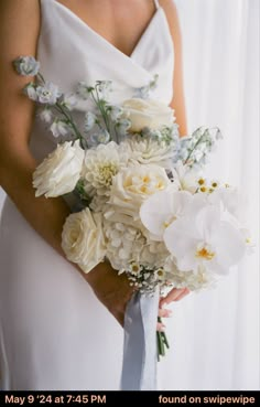 a bride holding a bouquet of white flowers