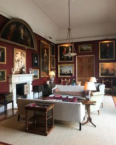 a living room filled with furniture and paintings on the wall above it's fireplace