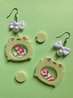 🐸Cute frog earrings with strawberries in its stomach. 🐸The bow and the pearls add a softer look to the earrings, and makes the frogs stand out. Also, the earrings function as a shaker as well.  🐸These dangle earrings are light weight and comfortable, and they're hypo-allergenic. Shaker Earrings, Toothpaste Kisses, Silly Earrings, Shrinky Dink Crafts, Frog Earrings, Frog Jewelry, Funky Earrings, Cute Frog, Jewelry Accessories Ideas