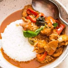 a bowl filled with rice, meat and veggies on top of a table