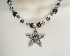 "This beautiful necklace has black pearl beads, black beads with silver engraved stars, seed beads, sterling silver plated filigree beads, pewter silver bead caps and a pewter silver pentagram. 18\" long. Sterling silver plated toggle clasp." Gothic Black Star Necklace, Black Gothic Star Necklace, Black Spacer Beads Jewelry For Festivals, Gothic Silver Jewelry With Black Beads, Black Necklaces With Silver Beads For Festival, Black Necklace With Silver Beads For Festival, Gothic Star-shaped Jewelry For Festivals, Handmade Black Star Necklace, Black Spiritual Star-shaped Jewelry