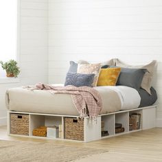 a bed with storage drawers underneath it in a room next to a window and rug