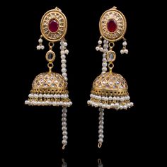 Perfect for luxurious formal festivities! The look includes a pair of earrings and a maang teekah. The beautiful jhumkey earrings are adorned with kundan stones, lab-created gemstones and faux pearl moti. The classic maang teekah is designed with gutka kundan and pearl moti hangings. Approximate earrings length is 3". Gold-plated on high-quality brass as base metal. Made by order. Kindly allow 4-6 weeks for the delivery of this item. For custom or urgent requests, please contact support@alacoutu Ceremonial Tilla Jhumkas For Eid, Ceremonial Kundan Jhumkas With Latkans, Party Kundan Jhumkas In Temple Jewelry Style, Ceremonial Kundan Tilla Earrings, Ceremonial Kundan Jhumkas, Temple Jewelry Kundan Jhumkas For Party, Kundan Jhumkas For Party, Temple Jewelry Style, Kundan Temple Jewelry Jhumkas For Party, Kundan Tilla Jhumkas For Eid