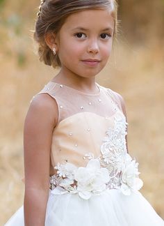 The Arielle Flower Girl Dress from Blush Kids sets the standard for elegance and whimsy in children's formal wear, promising to make any little girl feel like a princess on that special day. A highlight of the dress is its satin bodice, which exudes a timeless grace, perfectly complementing the delicate illusion neckline that adds a touch of sophistication. Adorned with 3D floral lace, the dress comes to life with textures that are both visually stunning and tactilely engaging. Sparkling crystal Princess Dress With Fitted Bodice For Bridesmaid Prom, Bridesmaid Princess Dress With Fitted Bodice For Prom, Princess Style Bridesmaid Pageant Dress With Lace Bodice, Princess Pageant Dress For Bridesmaids In Prom Season, Princess Style Pageant Dress For Bridesmaid During Prom Season, Princess Bridesmaid Pageant Dress For Prom, Princess Style Bridesmaid Pageant Dress For Prom Season, White Tulle Bridesmaid Dress For Pageant, Elegant Bridesmaid Dresses With Floral Applique