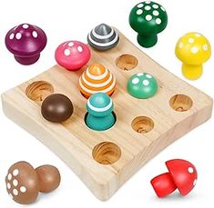 a wooden toy with different colored balls and shapes on it's surface, including mushrooms