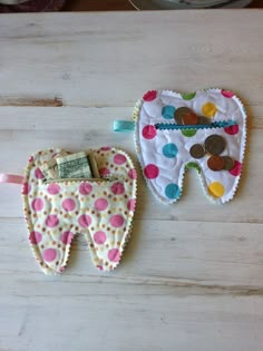 two toothbrush holders made out of fabric with buttons on them and money in the pocket