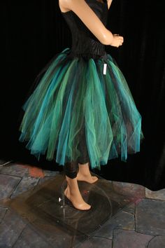 a mannequin dressed in a green and black tutu skirt with tags on it