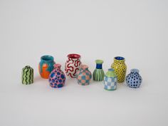 a group of colorful vases sitting on top of a white table