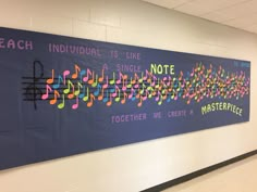 a bulletin board with music notes on it in a hallway next to a wall that reads teach individual, is like single note together we create masterpiece