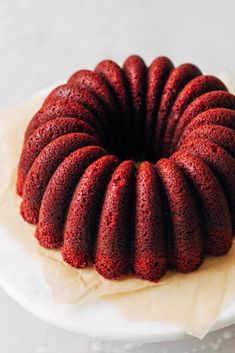 a bundt cake sitting on top of a white plate with wax paper around it