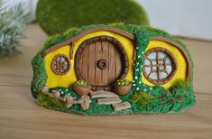 a small green and yellow hobbot sitting on top of a wooden table