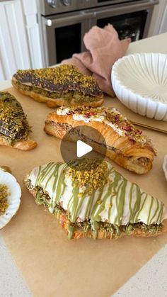 there are many different types of food on the counter top, including breads and pastries