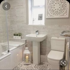 a bathroom with a white toilet, sink and bathtub next to a shower stall