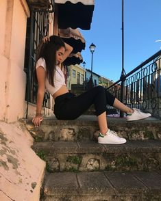 a woman is sitting on the steps with her leg up in front of her face