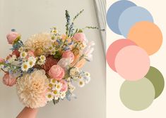 a person holding a bouquet of flowers in front of a wall with pastel colors