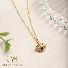 Eye-catching and elegant. A unique gold chain necklace with an amazing celestial gold pendant featuring evil eye with clear lashes. Have sapphire blue CZ set into the evil eye charm, it dazzles in the lights, accentuating the beauty of your skin and making you sparkly at any parities. Spiritual Gold Eye-shaped Necklace, Party Dangle Evil Eye Jewelry, Gold Dangle Jewelry With Evil Eye, Gold Symbolic Evil Eye Charm Necklaces, Gold Symbolic Charm Necklaces With Evil Eye, Symbolic Gold Evil Eye Charm Necklaces, Evil Eye Metal Jewelry For Parties, Metal Evil Eye Jewelry For Parties, Gold Eye Necklace With Diamond Eyes