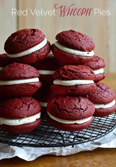 a stack of red velvet cookies with white frosting