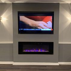 a flat screen tv mounted on the wall above a fireplace