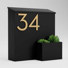 a black mailbox with a plant in it and the number 34 on the front