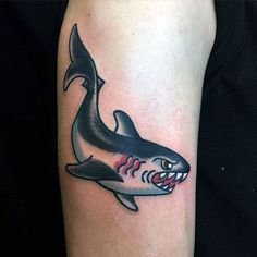 a shark tattoo on the left arm