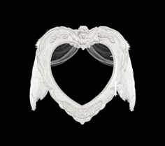 a white heart shaped frame with wings hanging from it's sides on a black background