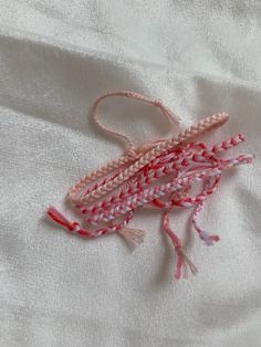 a close up of a piece of fabric on a white cloth with red and pink thread