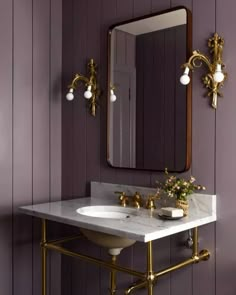 a bathroom with purple walls and gold fixtures