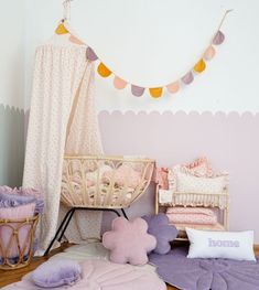 a baby's room is decorated in pastel colors and pinks, purples and whites