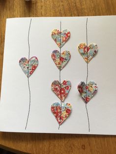 four paper hearts are hanging on a string