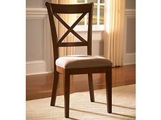 a wooden chair sitting in front of a window next to a rug on the floor