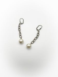 Pretty vintage dangle faux pearl earrings! Top is silver tone metal that is shaped like a shell with 6 link chain drop that has a faux pearl at the very end. Backings are meant for pierced ears and have a clip backing. No makers mark. Overall good condition. Minor wear and tarnish, free of rust and verdigris. Length of 2 and 5/8 inches. Discounts offered for bulk purchases. Shop accepts PayPal, credit cards, and Etsy gift cards. ♥Check out the rest of the shop♥ https://www.etsy.com/shop/artdecod Silver Earrings With Pearl Chain For Evening, Silver Pearl Chain Earrings For Evening, Silver Party Pearl Earrings With Pearl Chain, Silver Pearl Chain Earrings For Party, Party Pearl Charm Earrings, Silver Dangle Pearl Earrings, Party Pearl Earrings With Metal Charm, Metal Drop Earrings With Pearl Chain, Silver Clip-on Earrings With Pearl Drop