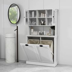 a white cabinet with two bins in front of it and a mirror on the wall