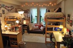 a dorm room with bunk beds, desks and other items in it's corner