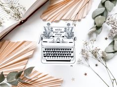 an old fashioned typewriter sticker on top of a book next to some flowers