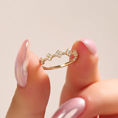 a woman's hand holding a gold ring that has been set on top of her finger