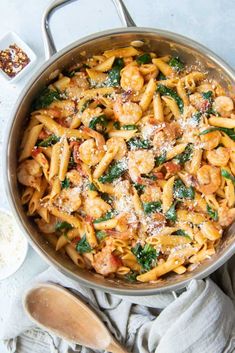 a pan filled with pasta and spinach covered in sauce