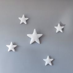 five white stars are arranged on a gray surface, with one star in the middle