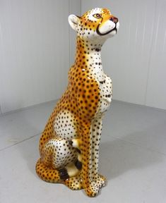 a ceramic cheetah sitting on the ground