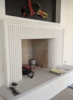 a fire place in the middle of a room with some tools on top of it